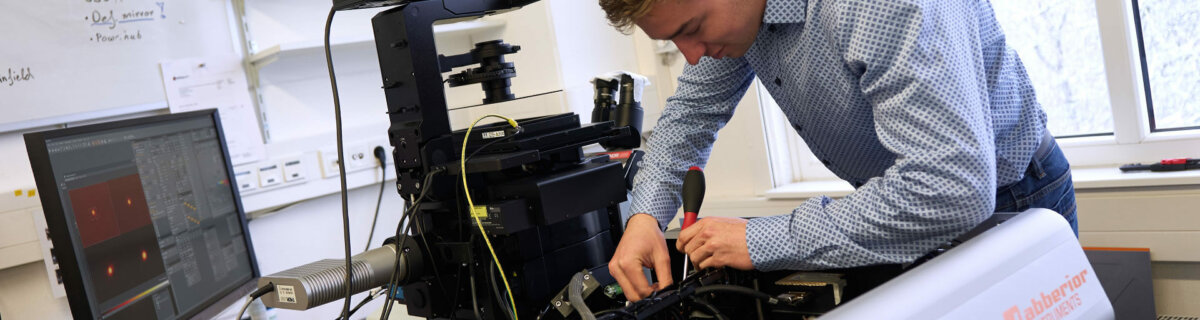 Hardware technician installing components in an abberior microscope