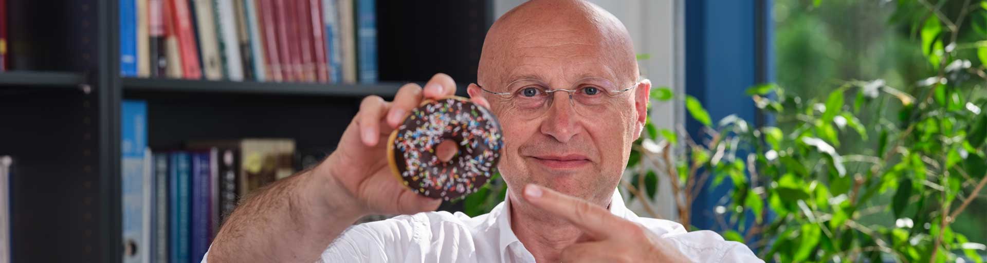 Nobel laureate Stefan W. Hell shows a donut, the symbol for his groundbreaking idea of a donut-shaped laser beam.
