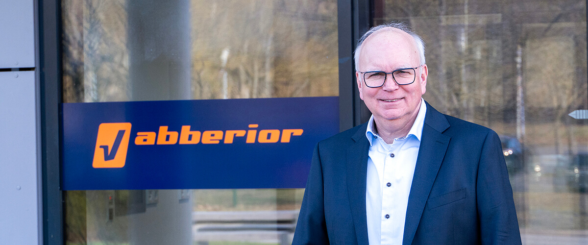 abberior instruments CEO Meiko Fiedler vor der Eingangstür des Unternehmens, im Hintergrund das Logo von abberior